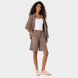 Modelka w oversize'owej bluzie medycznej Alice Mocha - brązowa koszulowa bluza scrubs z klasycznym kołnierzykiem, damska odzież medyczna Vena Uniformy