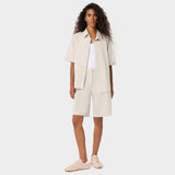 Modelka w oversize'owej bluzie medycznej Alice Nude - beżowa koszulowa bluza scrubs z klasycznym kołnierzykiem, damska odzież medyczna Vena Uniformy