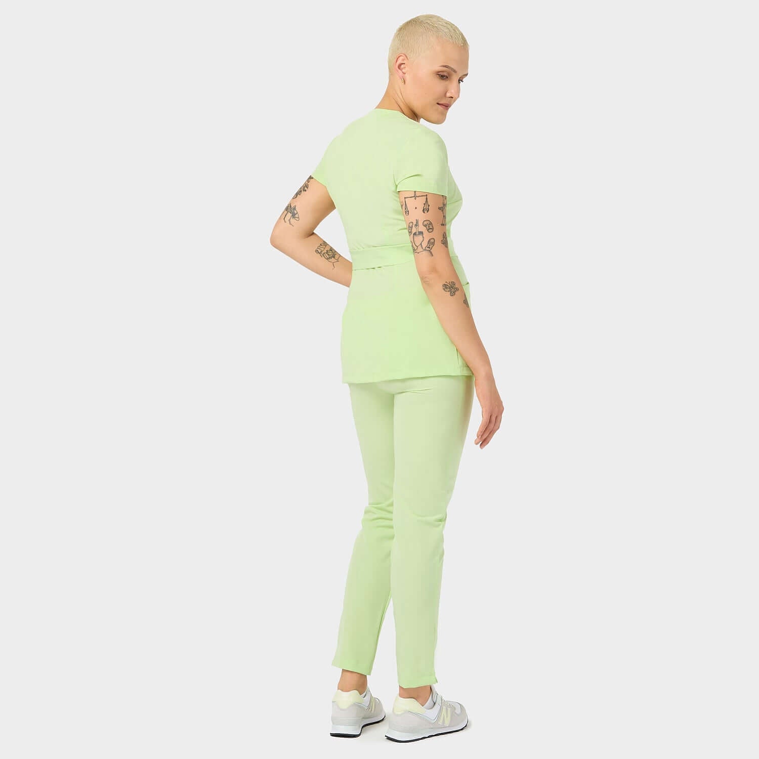 Fartuszek medyczny SOPHIA Matcha z tyłu: Widok fartuszka medycznego w kolorze Matcha z tyłu, ukazujący nowoczesny krój i stylowe wykończenia.