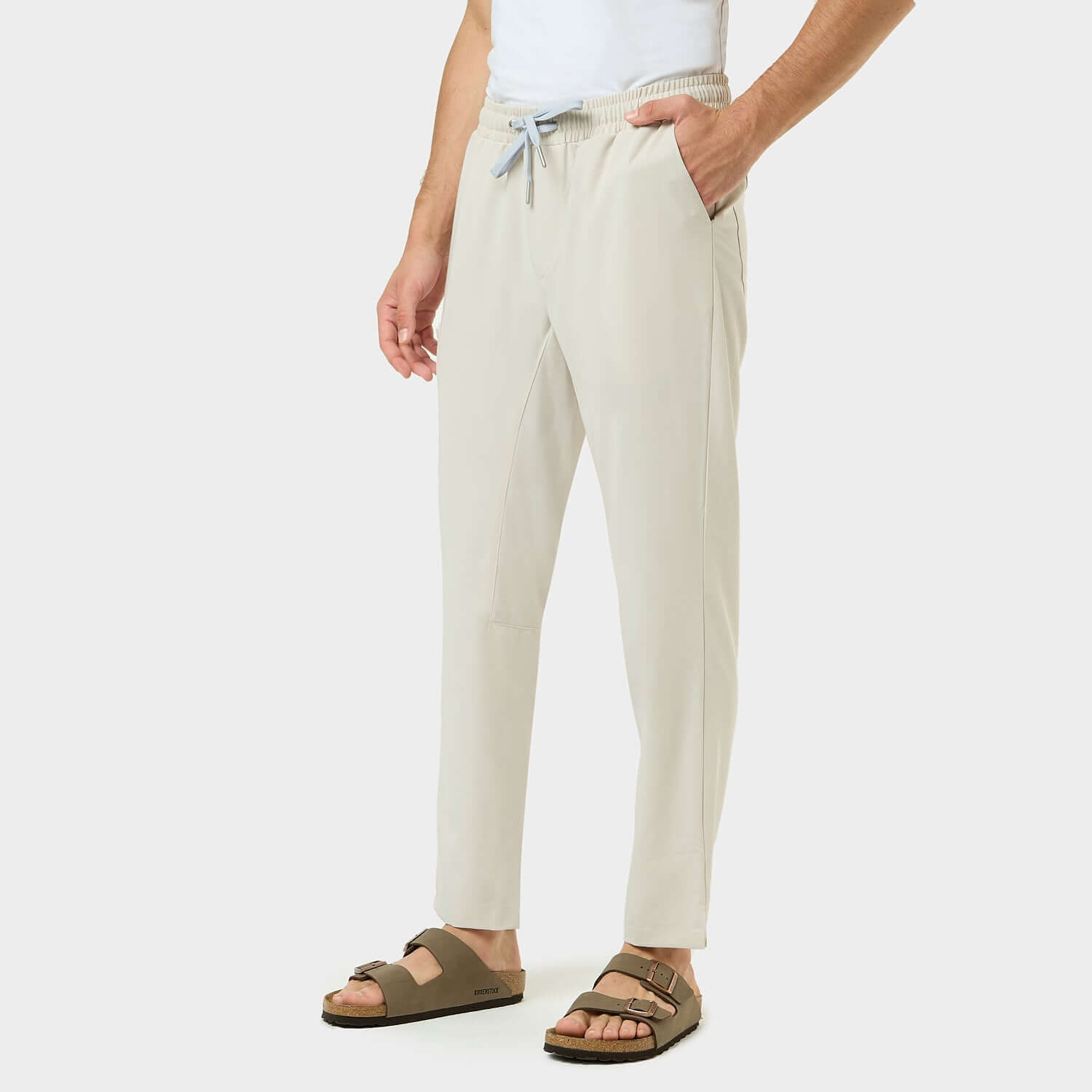 Mężczyzna w spodniach medycznych męskich coconut w dynamicznej pozie.