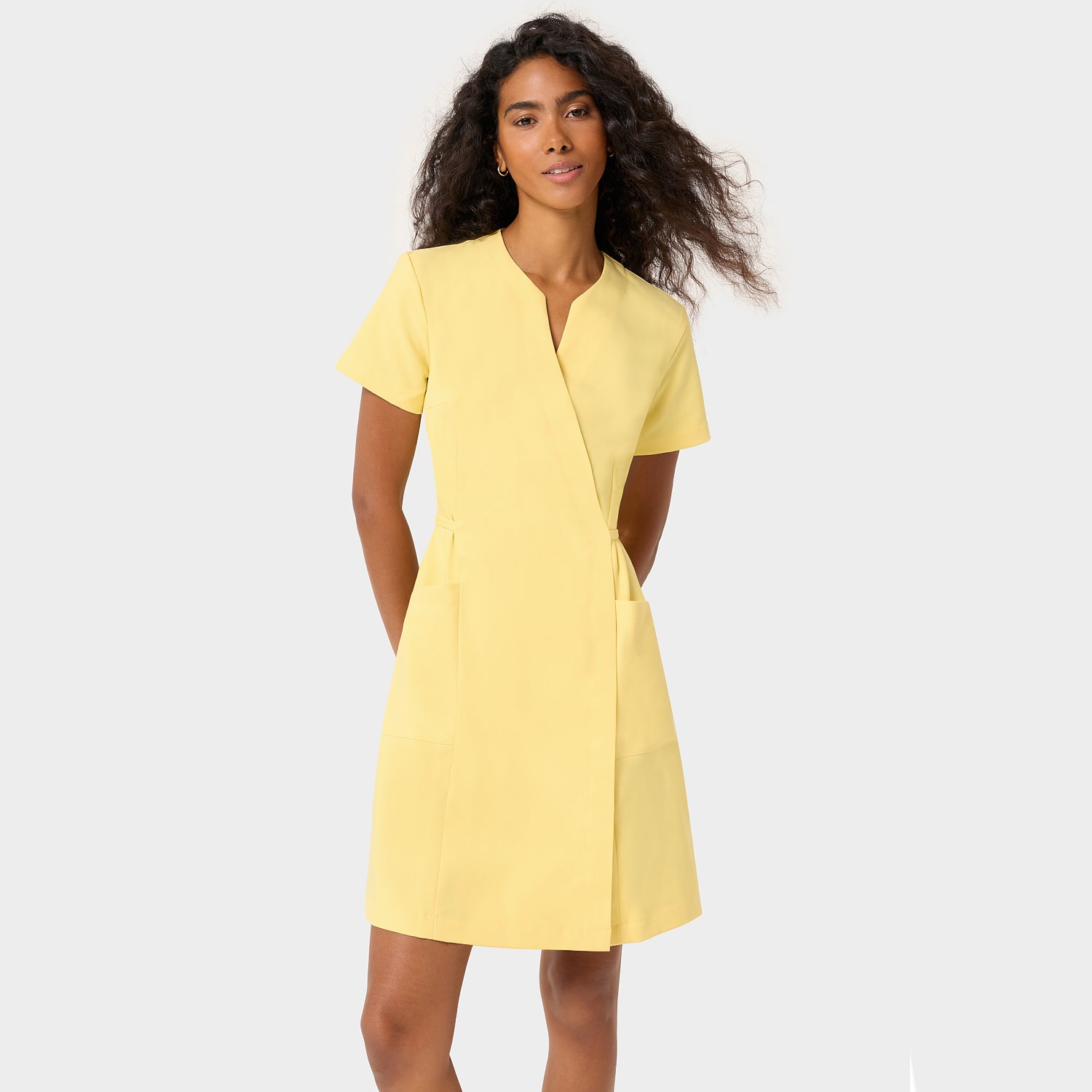 Kobieta w sukience medycznej Kate Butter Yellow — masłowo-żółta sukienka scrubs z wiskozy z elastanem, damska odzież medyczna Vena Uniformy