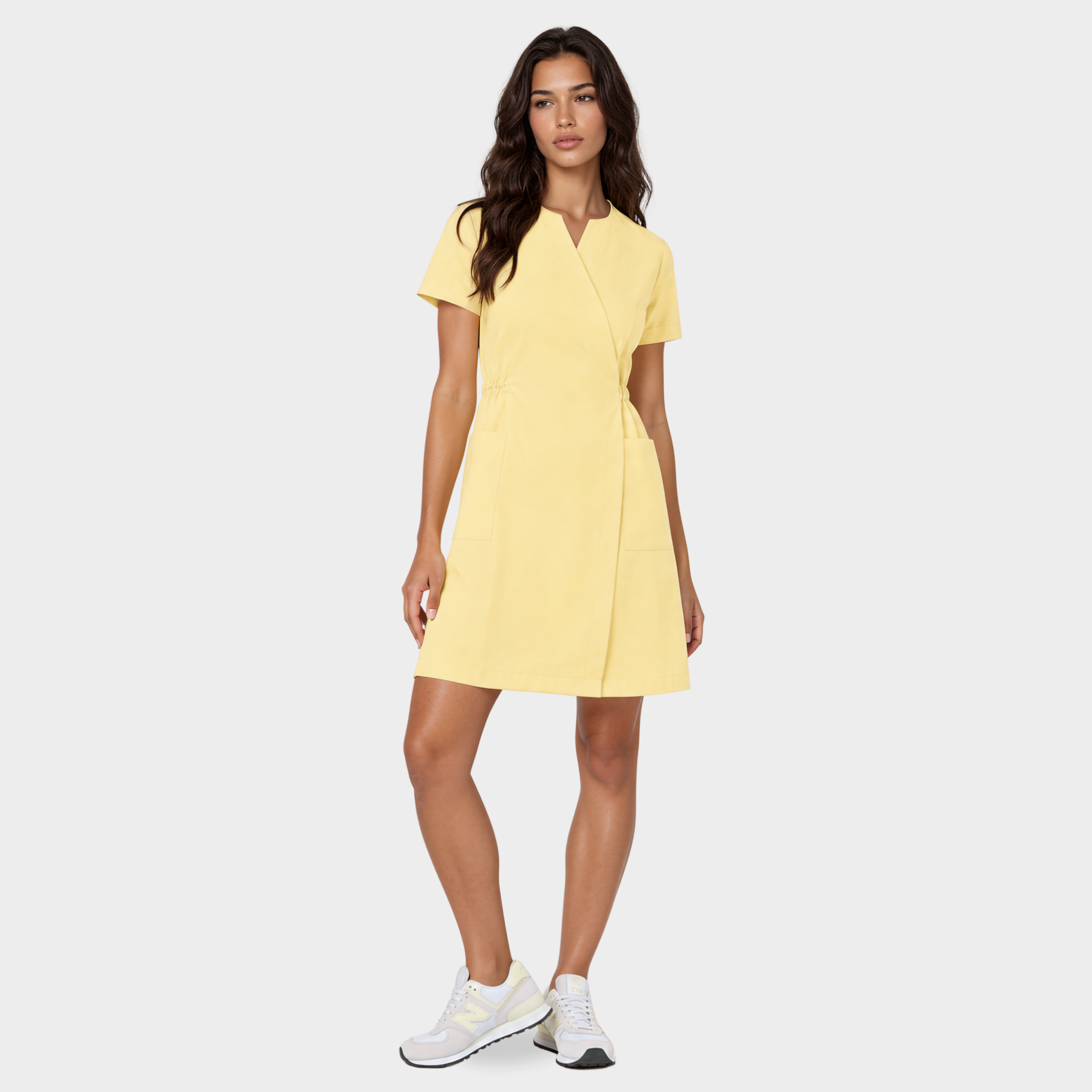 Kobieta w sukience medycznej damskiej Kate, wiązanej w pasie. W kolorze Butter Yellow