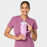 Modelka w sukience medycznej Kate w kolorze Berry Crush – nowoczesny, taliowany krój z krótkim rękawem i kieszeniami, idealna do pracy w placówkach medycznych.