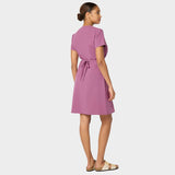 Modelka w sukience medycznej Kate w kolorze Berry Crush – nowoczesny, taliowany krój z krótkim rękawem i kieszeniami, idealna do pracy w placówkach medycznych.